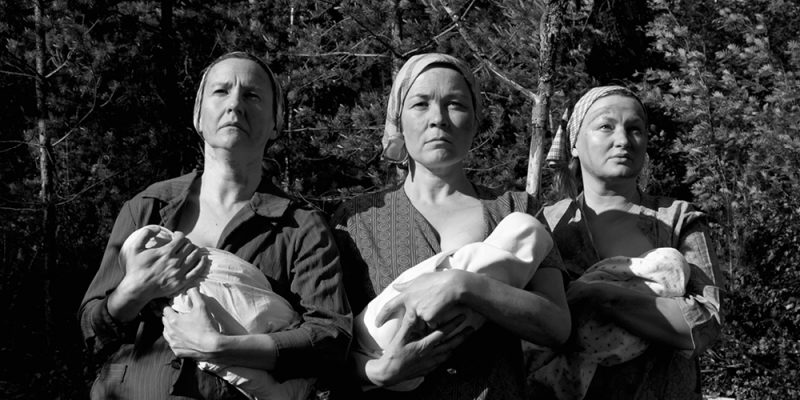 Mustavalkoinen kuva, jossa kolme naista pitävät vauvoja sylissään.